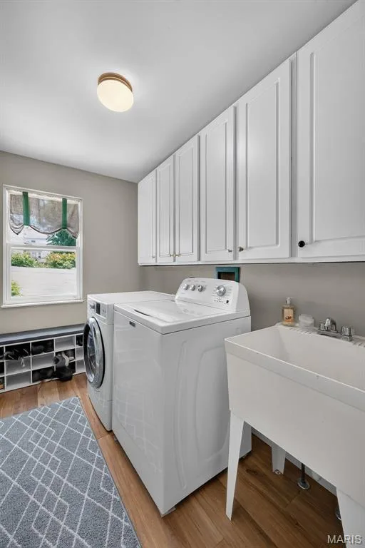 White shaker-style cabinetry, wood-finish flooring, and a utility sink — 10 Docs Ct., St Charles, MO 63303