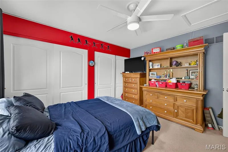 Built-in closet system with panel doors, overhead ceiling fan with integrated lighting, and carpeted flooring — 10 Docs Ct., St Charles, MO 63303