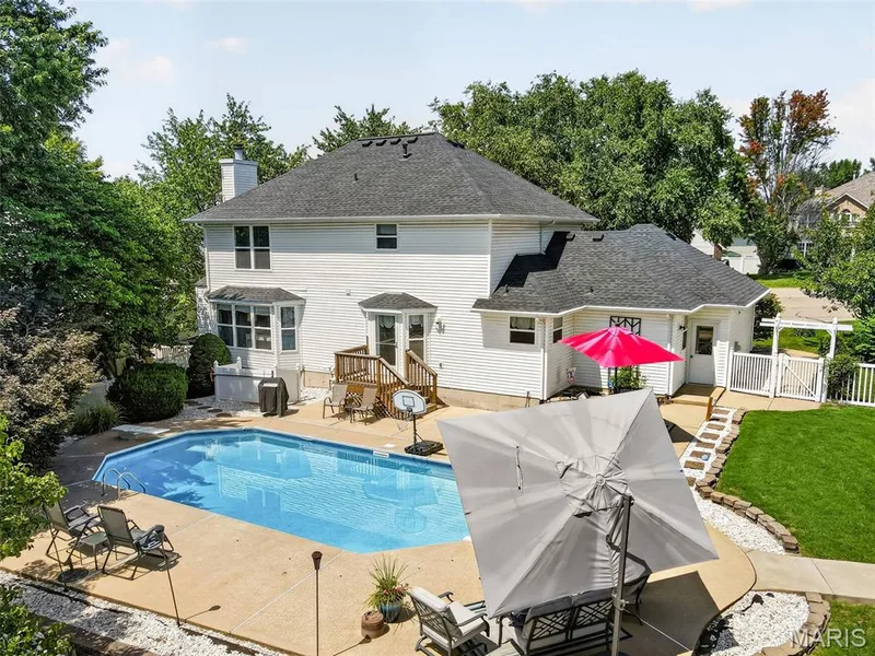 Expansive outdoor living area featuring an in-ground swimming pool, a multi-level deck, and a fenced yard with a gate — 10 Docs Ct., St Charles, MO 63303