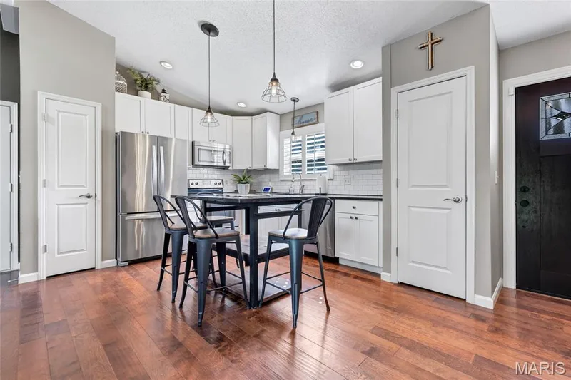 A timeless mix of warm wood tones, crisp white Shaker cabinetry, and sleek dark countertops for the perfect balance of cozy and modern. — 601 Big Timber Lane, O'Fallon, MO 63368