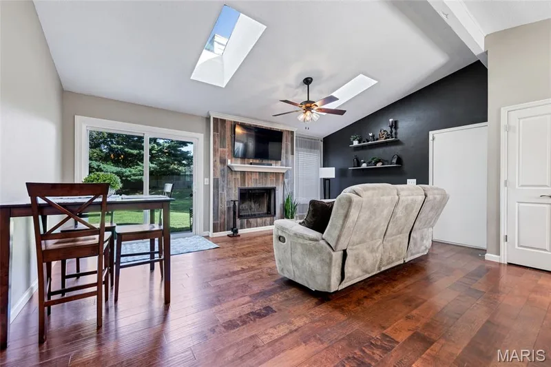Sun-drenched and effortlessly cozy. Soaring vaulted ceilings and dual skylights bring the light, while warm wood floors and a custom tiled fireplace set the mood. — 601 Big Timber Lane, O'Fallon, MO 63368