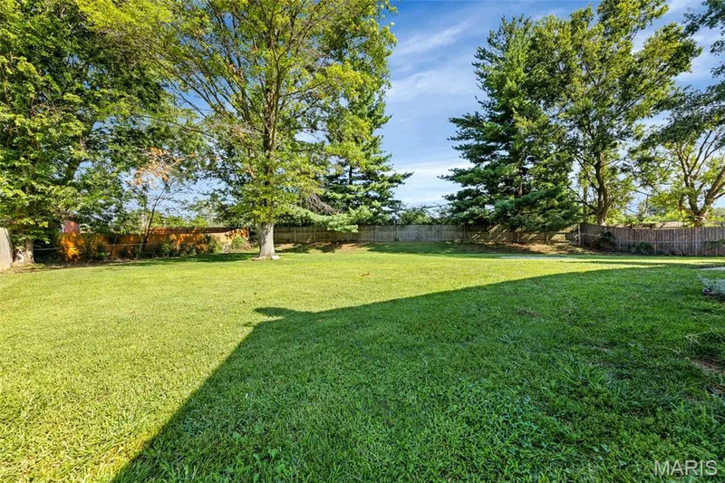 Expansive green lawn with mature trees and perimeter fencing — 601 Big Timber Lane, O'Fallon, MO 63368