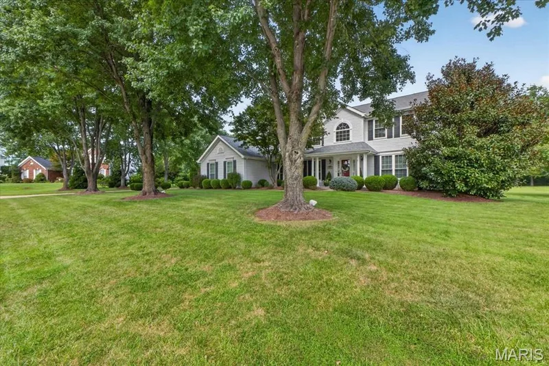 Two-story residence featuring a covered front porch, arched window, and dark window shutters — 5856 Canterfield Court, Weldon Spring, MO 63304
