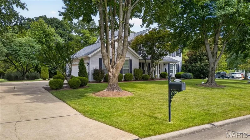 Two-story residence with white siding and dark shutters, featuring a prominent front entrance and an attached garage — 5856 Canterfield Court, Weldon Spring, MO 63304