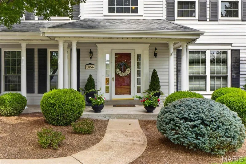 Siding exterior with a covered entry, columned porch, and a concrete pathway — 5856 Canterfield Court, Weldon Spring, MO 63304