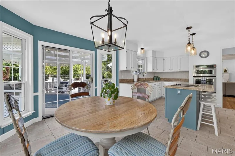 Kitchen featuring white cabinetry, granite countertops, tile flooring, and stainless steel double ovens — 5856 Canterfield Court, Weldon Spring, MO 63304