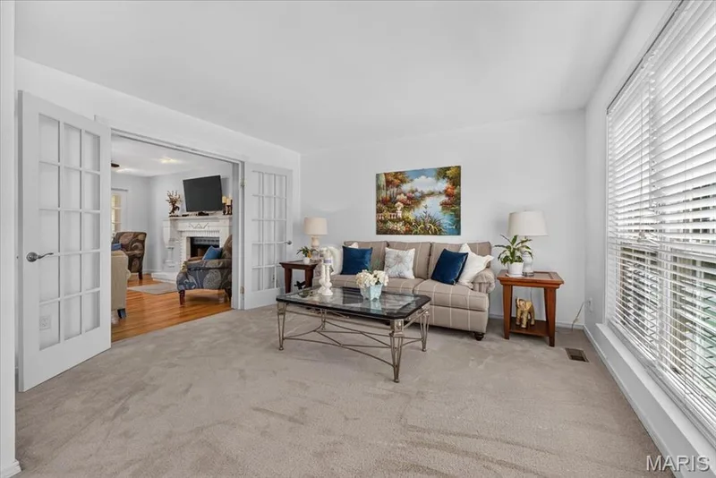 Light carpeting, white walls, large window with blinds, and double French doors with a multi-pane design — 5856 Canterfield Court, Weldon Spring, MO 63304