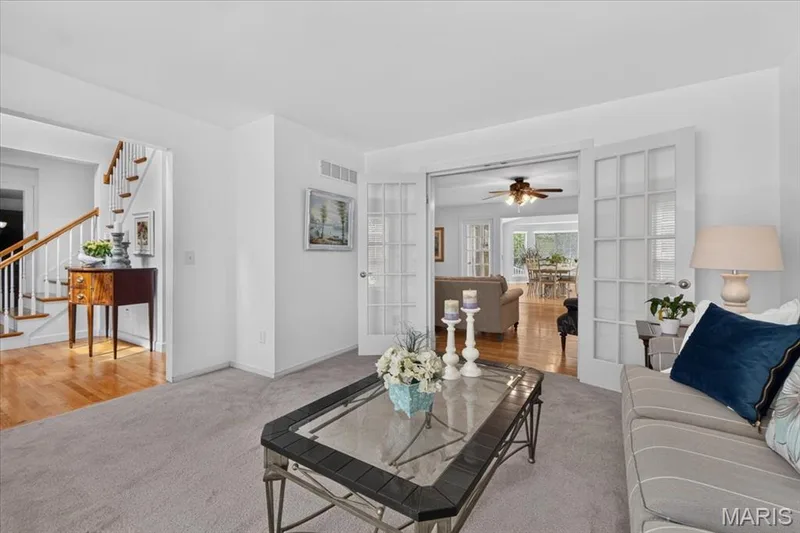 Plush carpeting, bright white walls, and elegant French doors with grid-patterned lites — 5856 Canterfield Court, Weldon Spring, MO 63304