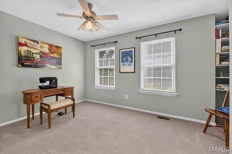 Wall-to-wall carpeting with light-toned walls, dual windows, a ceiling fan with integrated lighting, and built-in shelving — 5856 Canterfield Court, Weldon Spring, MO 63304