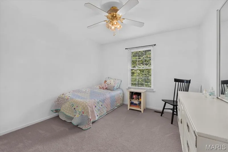 Carpeted room featuring a ceiling fan with integrated lighting, a window with blinds, and white walls — 5856 Canterfield Court, Weldon Spring, MO 63304