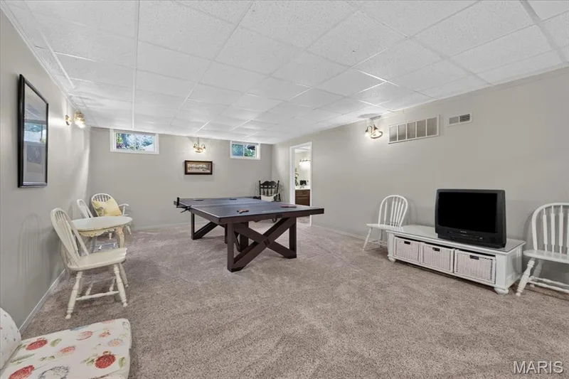 Carpeted room with drop ceiling, wall sconces, and recessed windows — 5856 Canterfield Court, Weldon Spring, MO 63304