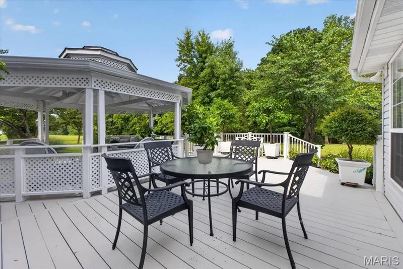 Expansive outdoor deck with a white painted surface, lattice railing, and a built-in gazebo — 5856 Canterfield Court, Weldon Spring, MO 63304