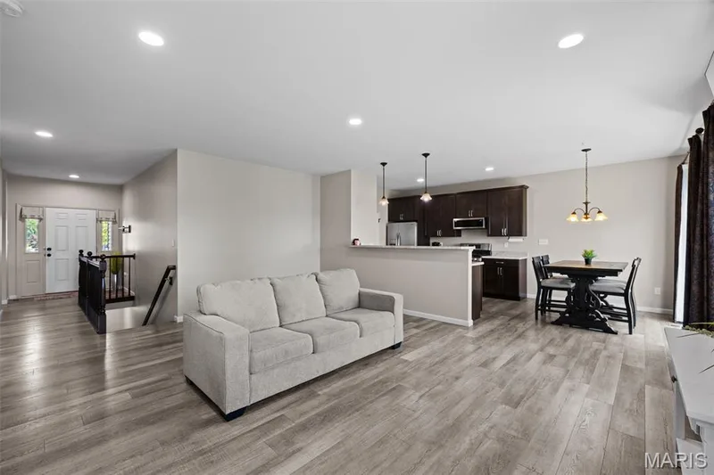 Spacious living room, steps to lower level, and breakfast bar — 213 Charlestowne Place Drive, St Charles, MO 63301