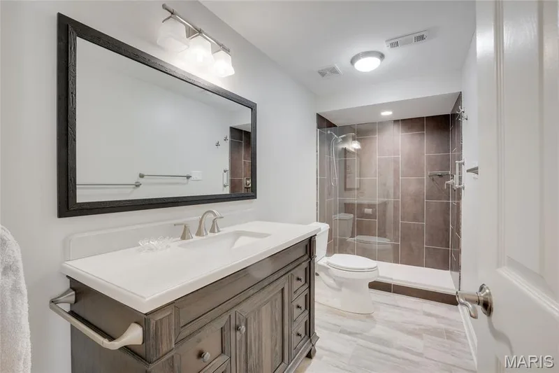 Vanity with a single basin, stone countertop, and wood-finish cabinetry — 2508 Peppermill Lake Court, Chesterfield, MO 63005