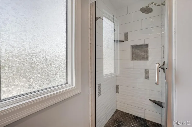 Walk-in shower with clear glass enclosure and dark hexagonal tile flooring — 2508 Peppermill Lake Court, Chesterfield, MO 63005
