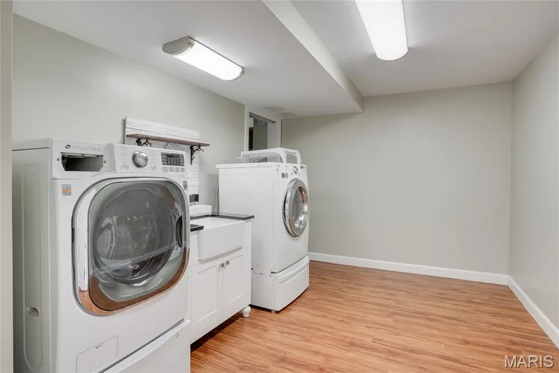 White cabinetry with a farmhouse-style sink, and overhead fluorescent lighting — 2508 Peppermill Lake Court, Chesterfield, MO 63005