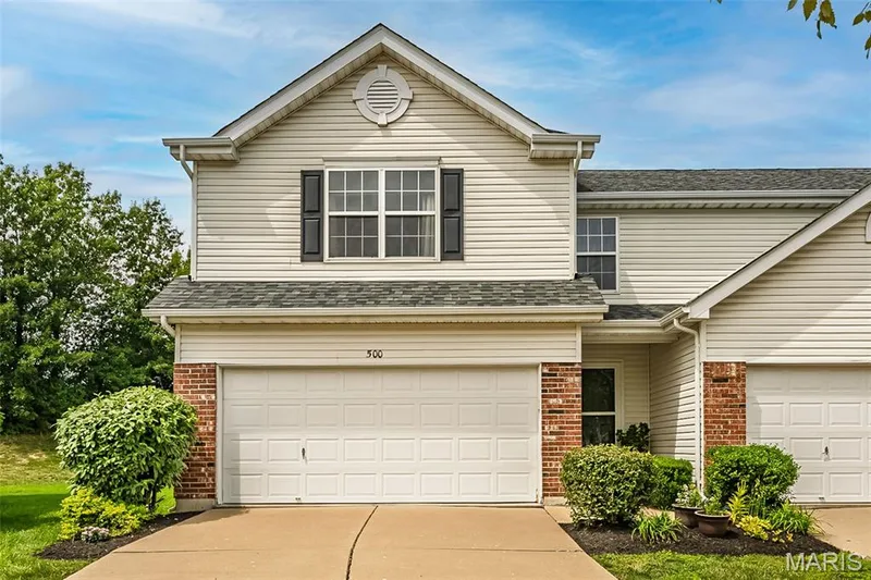 Front exterior featuring light-toned siding and brick accents — 500 Flowering Magnolia Drive, O'Fallon, MO 63366