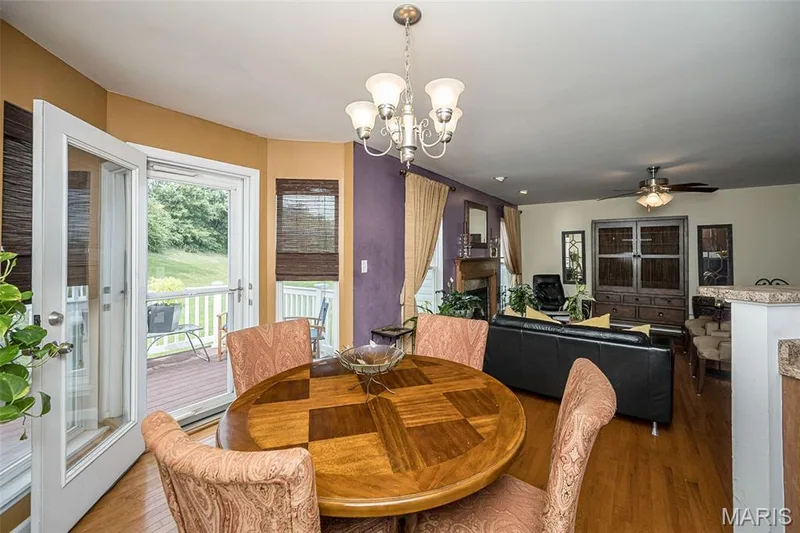 Hardwood flooring, white French doors, recessed fireplace, ceiling fan, and chandelier lighting — 500 Flowering Magnolia Drive, O'Fallon, MO 63366