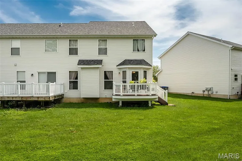 Rear exterior with two distinct wood decks, white vinyl siding, multiple windows, and a bay window feature — 500 Flowering Magnolia Drive, O'Fallon, MO 63366