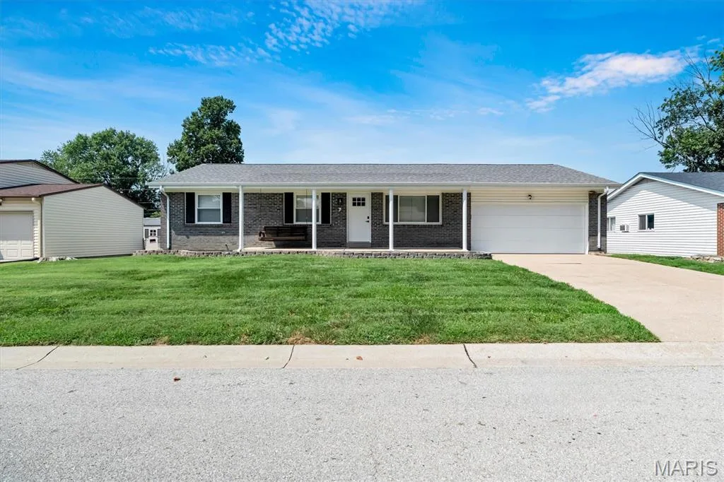 Ranch-style residence featuring a dark brick facade, white columned porch, and an attached two-car garage — 7 Saint Mark Drive, St Peters, MO 63376