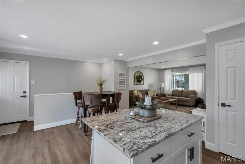 Kitchen island with stone countertop, recessed lighting, wood-finish flooring, half-wall partition, and white paneled doors — 7 Saint Mark Drive, St Peters, MO 63376