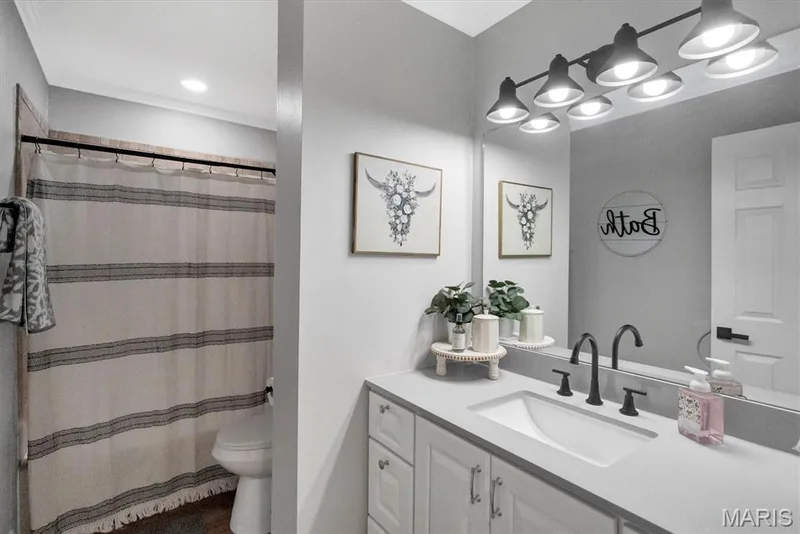Vanity with an integrated rectangular sink, matte black two-handle faucet, and white cabinetry — 7 Saint Mark Drive, St Peters, MO 63376