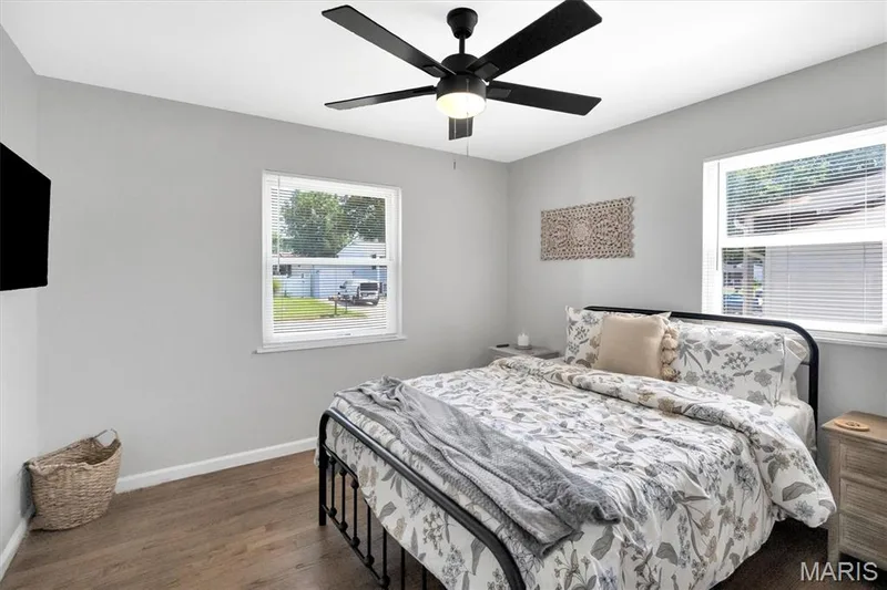 Wood-finish flooring, light gray walls, white trim, and a black ceiling fan with integrated lighting — 7 Saint Mark Drive, St Peters, MO 63376