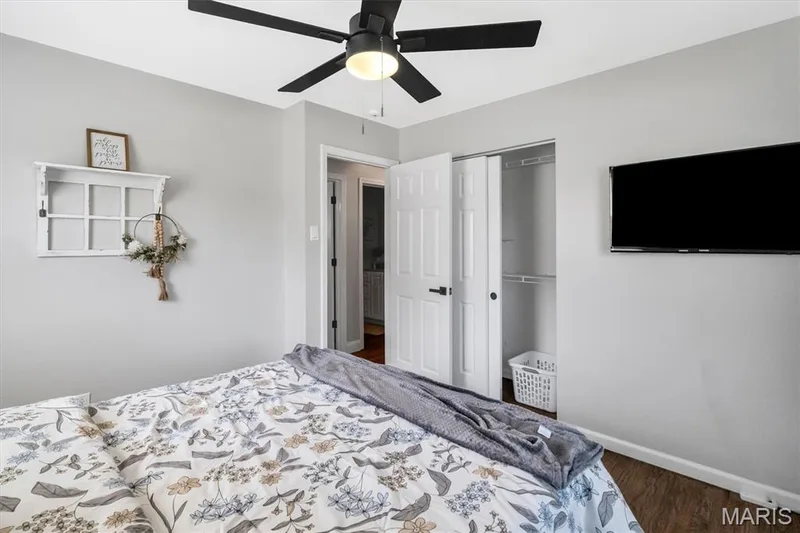 Ceiling fan with black blades, wood-finish flooring, white walls, and a closet with bi-fold doors — 7 Saint Mark Drive, St Peters, MO 63376