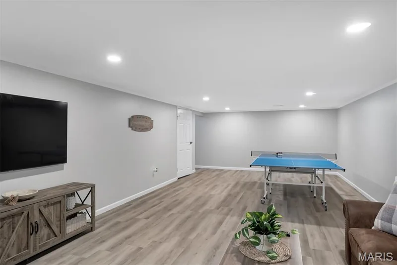 Finished lower level featuring recessed lighting, light gray walls, wood-finish flooring, and white trim — 7 Saint Mark Drive, St Peters, MO 63376