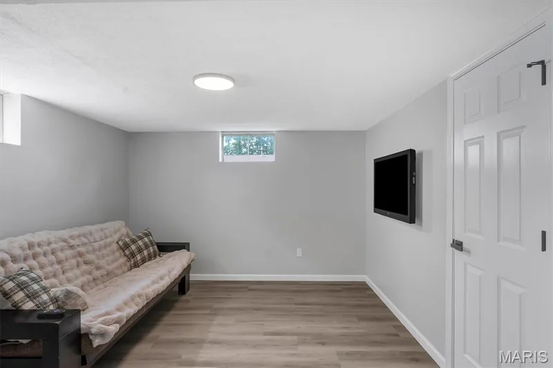 Recessed windows, wood-finish flooring, white paneled door with black hardware, and light gray wall finish — 7 Saint Mark Drive, St Peters, MO 63376