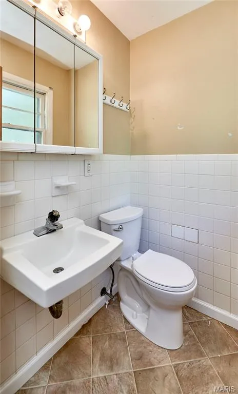 Pedestal sink, wall-mounted medicine cabinet with integrated lighting, toilet, and tiled flooring — 318 Capri Drive, O'Fallon, MO 63366