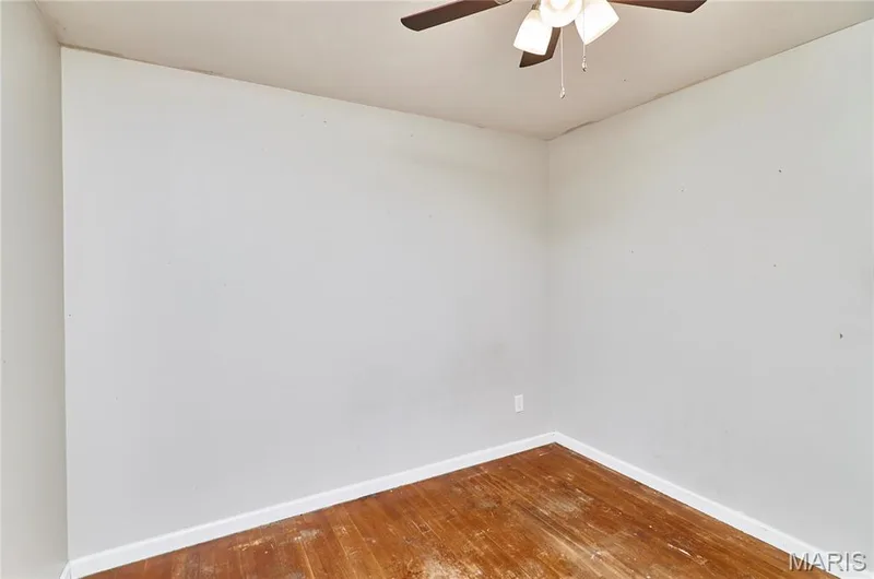 Wood-finish flooring with white trim, light-toned walls, and a ceiling fan with integrated lighting — 318 Capri Drive, O'Fallon, MO 63366