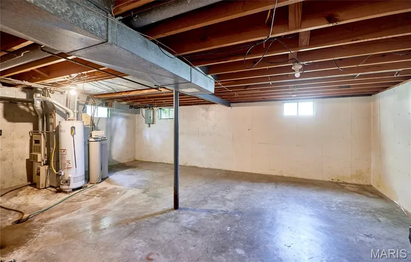Unfinished basement with exposed ceiling joists and concrete flooring — 318 Capri Drive, O'Fallon, MO 63366