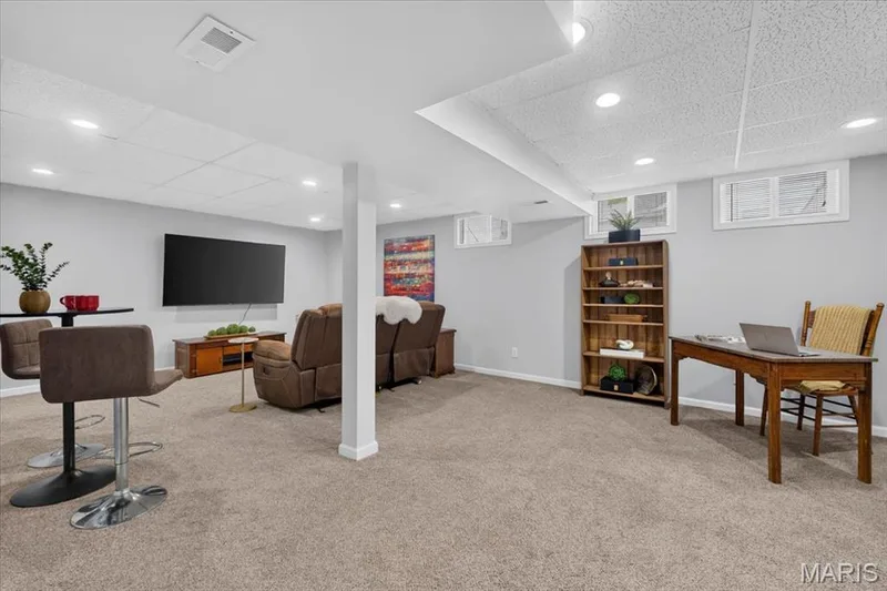 Carpeted lower level with recessed lighting, painted walls, and built-in shelving — 35 Snowmass Court, O'Fallon, MO 63368