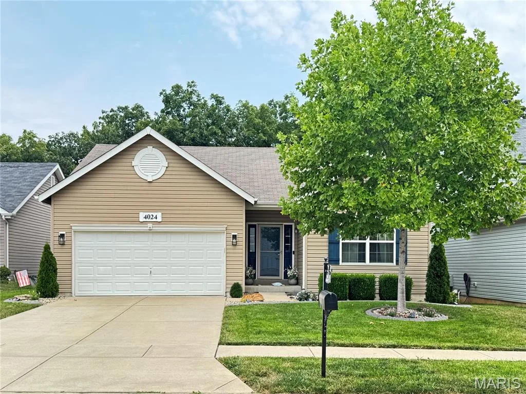 Exterior featuring tan siding, a two-car garage, and a concrete driveway — 4024 Glengarry Drive, Wentzville, MO 63385