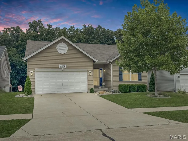 Siding exterior with an attached garage, concrete driveway, and front landscaping — 4024 Glengarry Drive, Wentzville, MO 63385