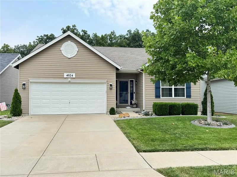 Single-story residence featuring light-toned siding, an attached garage, and a concrete driveway — 4024 Glengarry Drive, Wentzville, MO 63385