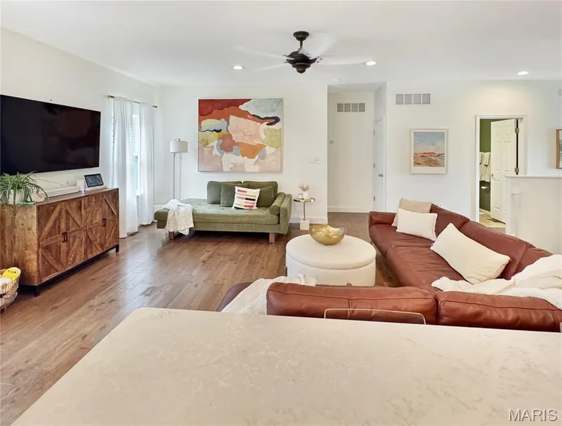 Open-concept living space with wood-finish flooring, recessed lighting, and a ceiling fan — 4024 Glengarry Drive, Wentzville, MO 63385