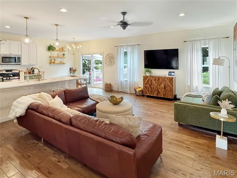 Open-concept living area with wood-finish flooring, recessed lighting, and a ceiling fan — 4024 Glengarry Drive, Wentzville, MO 63385