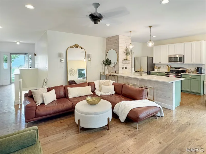 Open-concept living area with wood-finish flooring, recessed lighting, and a ceiling fan — 4024 Glengarry Drive, Wentzville, MO 63385