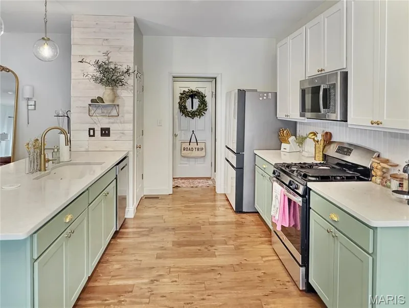 Kitchen featuring hardwood-style flooring, white upper cabinetry, and green lower cabinetry — 4024 Glengarry Drive, Wentzville, MO 63385