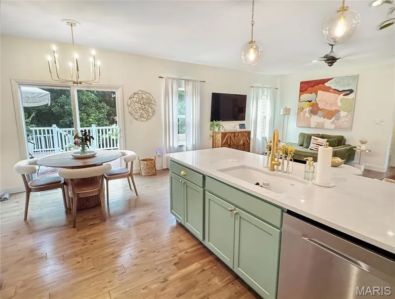 Kitchen island with light green cabinetry, white countertop, and integrated sink — 4024 Glengarry Drive, Wentzville, MO 63385