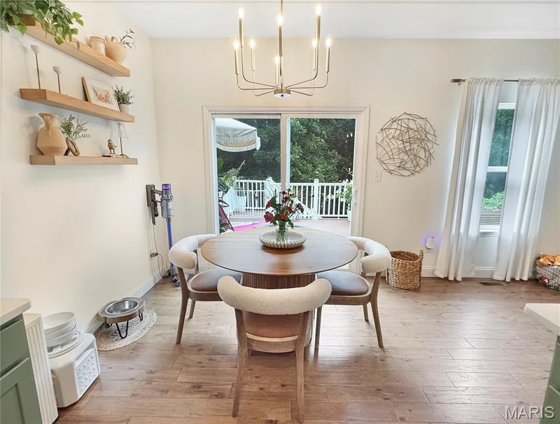 Wood-finish flooring with a modern ceiling light fixture, white walls, and a sliding glass door leading to a deck — 4024 Glengarry Drive, Wentzville, MO 63385