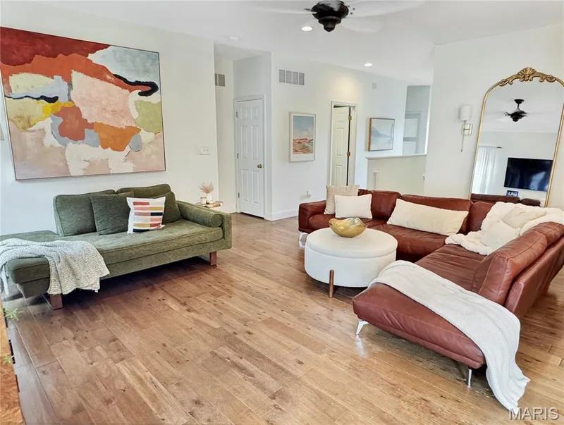 Wood-finish flooring throughout the space, recessed lighting, white walls, and ceiling fans — 4024 Glengarry Drive, Wentzville, MO 63385