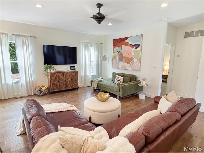 Spacious living area featuring wood-finish flooring, recessed lighting, and a ceiling fan — 4024 Glengarry Drive, Wentzville, MO 63385
