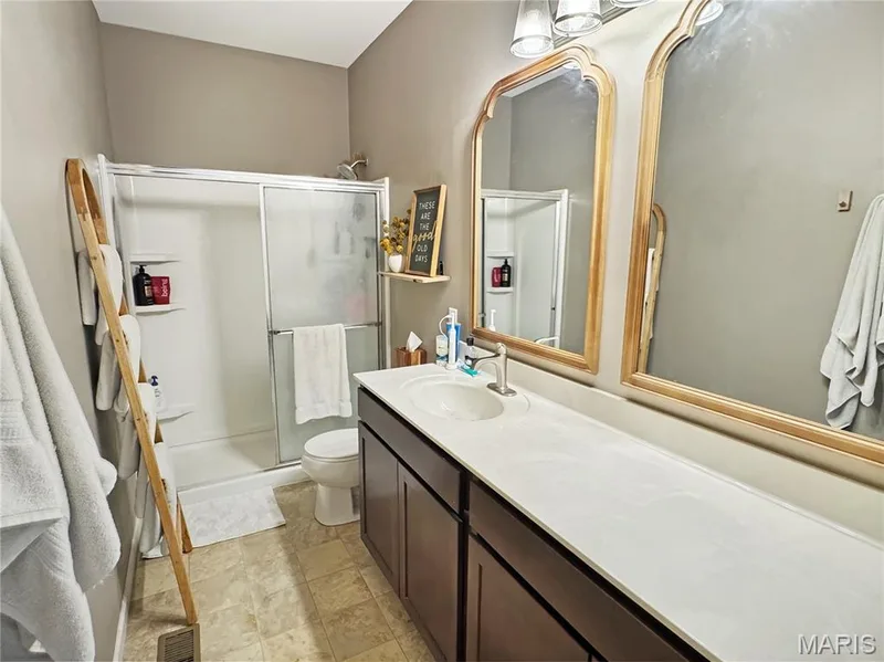 Dual vanity with integrated sinks, expansive countertop, and dark wood-finish cabinetry — 4024 Glengarry Drive, Wentzville, MO 63385