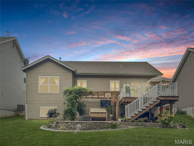 Expansive backyard with a tiered deck, pergola, and built-in stone landscaping — 4024 Glengarry Drive, Wentzville, MO 63385