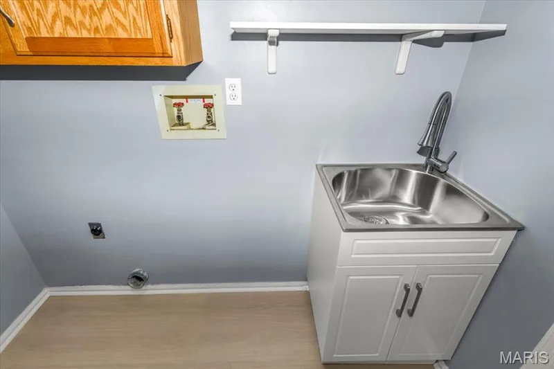 Laundry room from kitchen with garage access. Laundry sink and cabinet. — 1346 Cherry Glen Court, Chesterfield, MO 63017