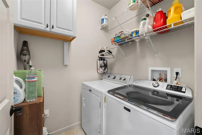 Laundry area featuring white cabinetry, wood-finish shelving, and wire shelving — 2700 Grover Crossing Drive, Wildwood, MO 63040
