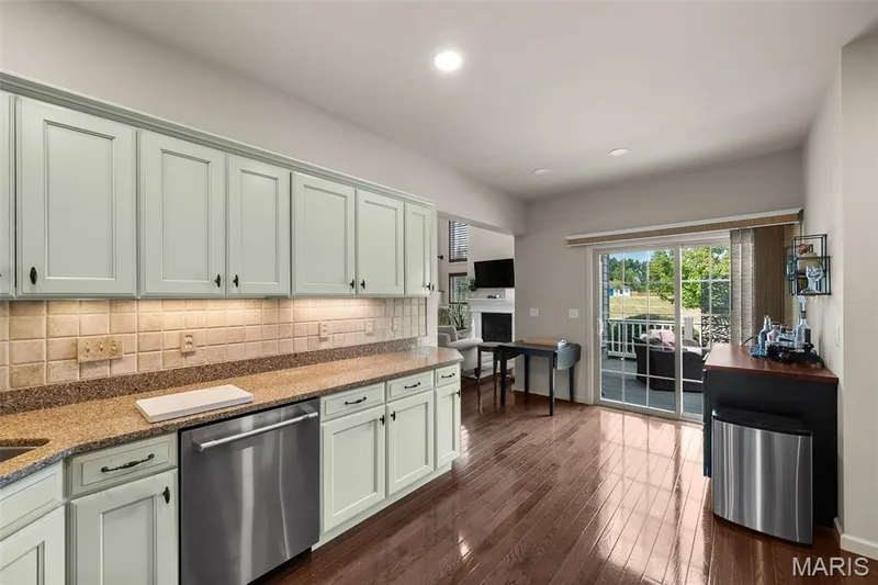 Kitchen featuring wood-finish flooring, light cabinetry, stone countertops, and stainless steel appliances — 2700 Grover Crossing Drive, Wildwood, MO 63040